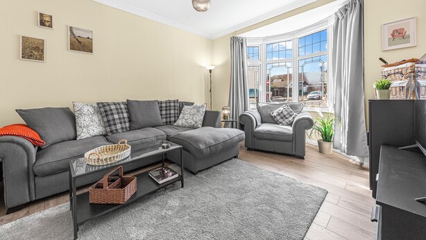 A modern living room with a grey sofa, a coffee table, and a view of the street through large windows. - Modern 4BR Home|Sleep 7|Free Parking|Self check in (Southend-on-Sea)