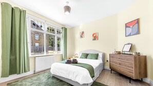 A bedroom with a bed, dresser, and artwork on the wall. - Modern 4BR Home|Sleep 7|Free Parking|Self check in (Southend-on-Sea)