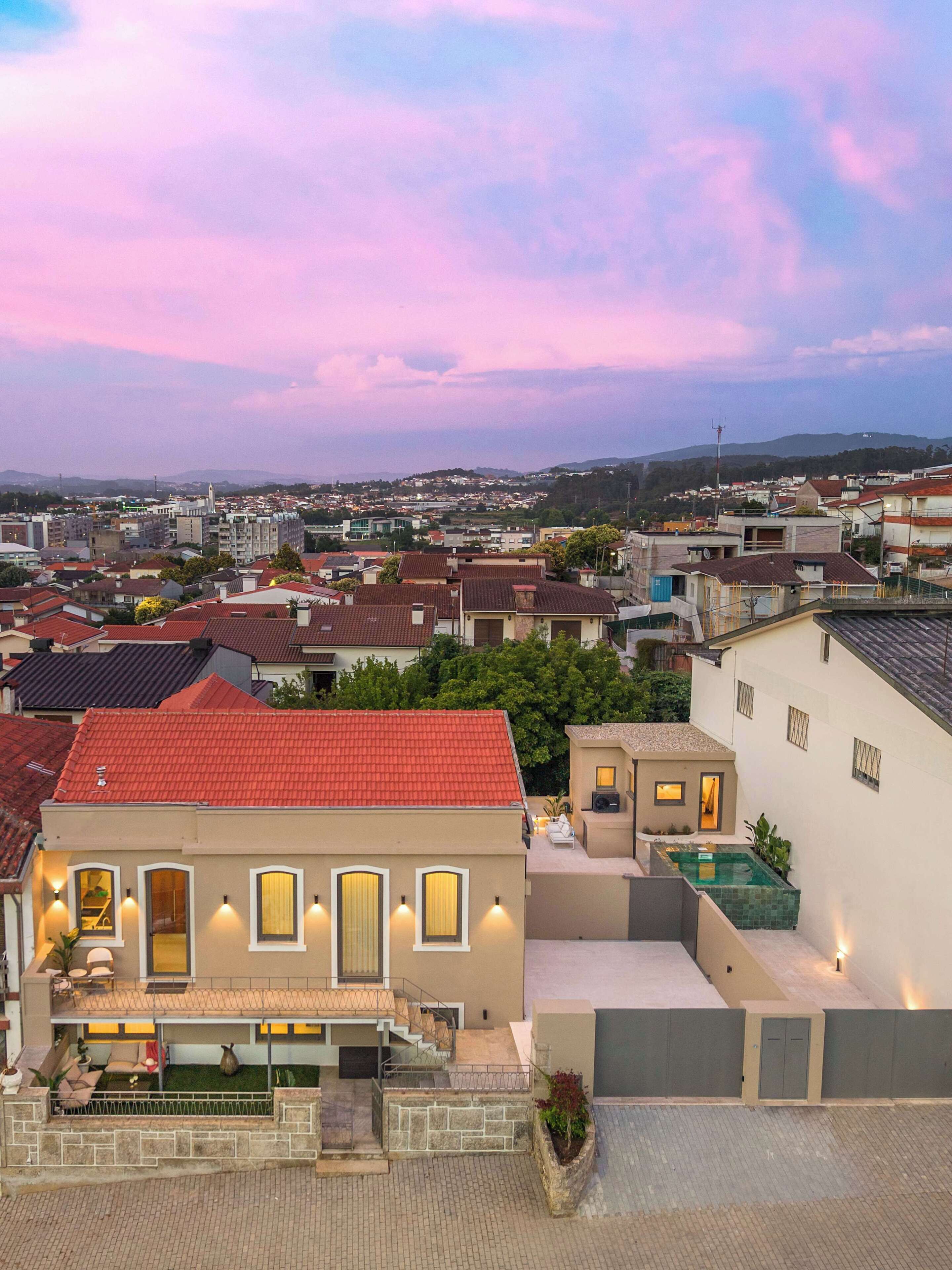 A residential area with a building featuring a balcony, a swimming pool, and a view of the surrounding neighborhood.