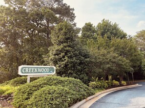 Ein Straßenschild für Creekwood, umgeben von dichtem Grün und Bäumen.