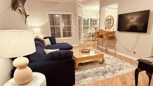 A living room with a sofa, coffee table, and a television. - Curated coastal flat 2BR/2BA close to the beach and outlets (Rehoboth Beach)