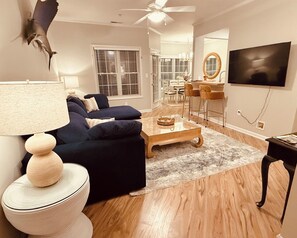 Ein Wohnzimmer mit einer Couch, einem Couchtisch und einem Fernseher.