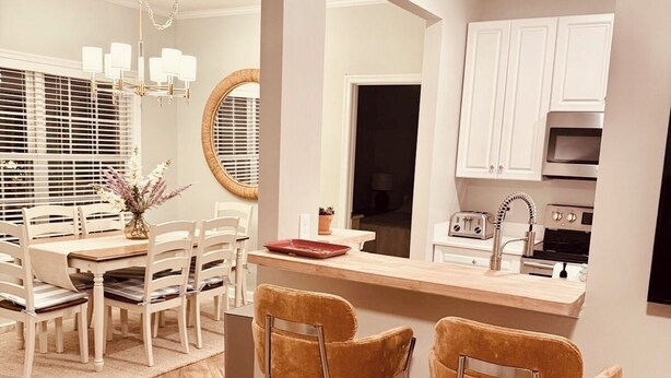 A modern kitchen with white cabinets, a stainless steel oven, and a built-in microwave. - Curated coastal flat 2BR/2BA close to the beach and outlets (Rehoboth Beach)