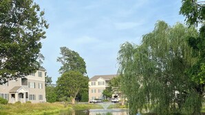 A residential area with houses, a pond, and a grassy field. - Curated coastal flat 2BR/2BA close to the beach and outlets (Rehoboth Beach)