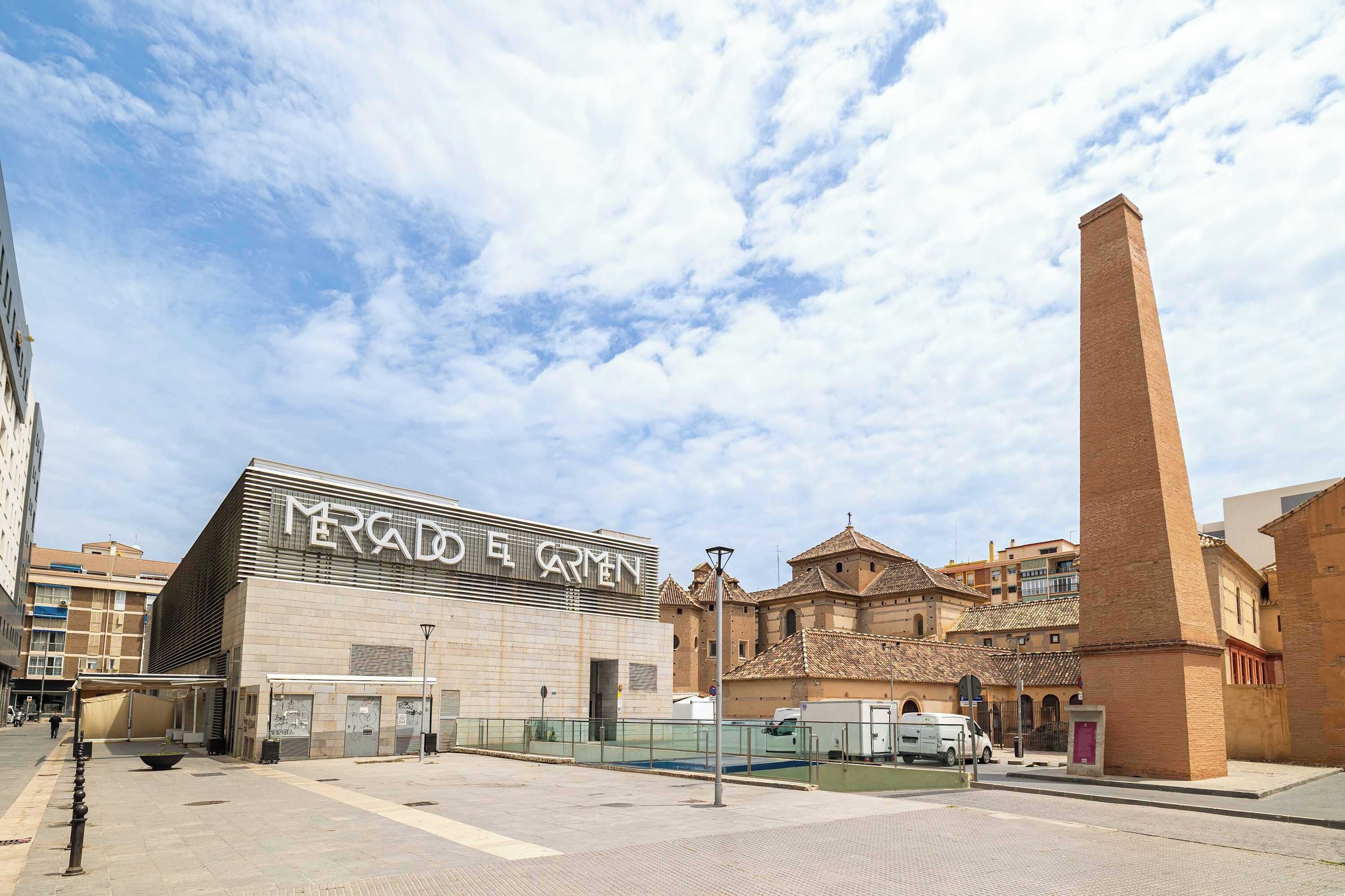 Um edifício com uma grande placa indicando 'MERAD DE ARMEN' e uma alta torre de tijolos.