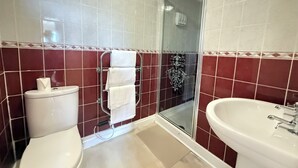 A bathroom with a toilet, a glass shower enclosure, and a sink. - Belgravia Holiday Apartments No 6 (Torquay)
