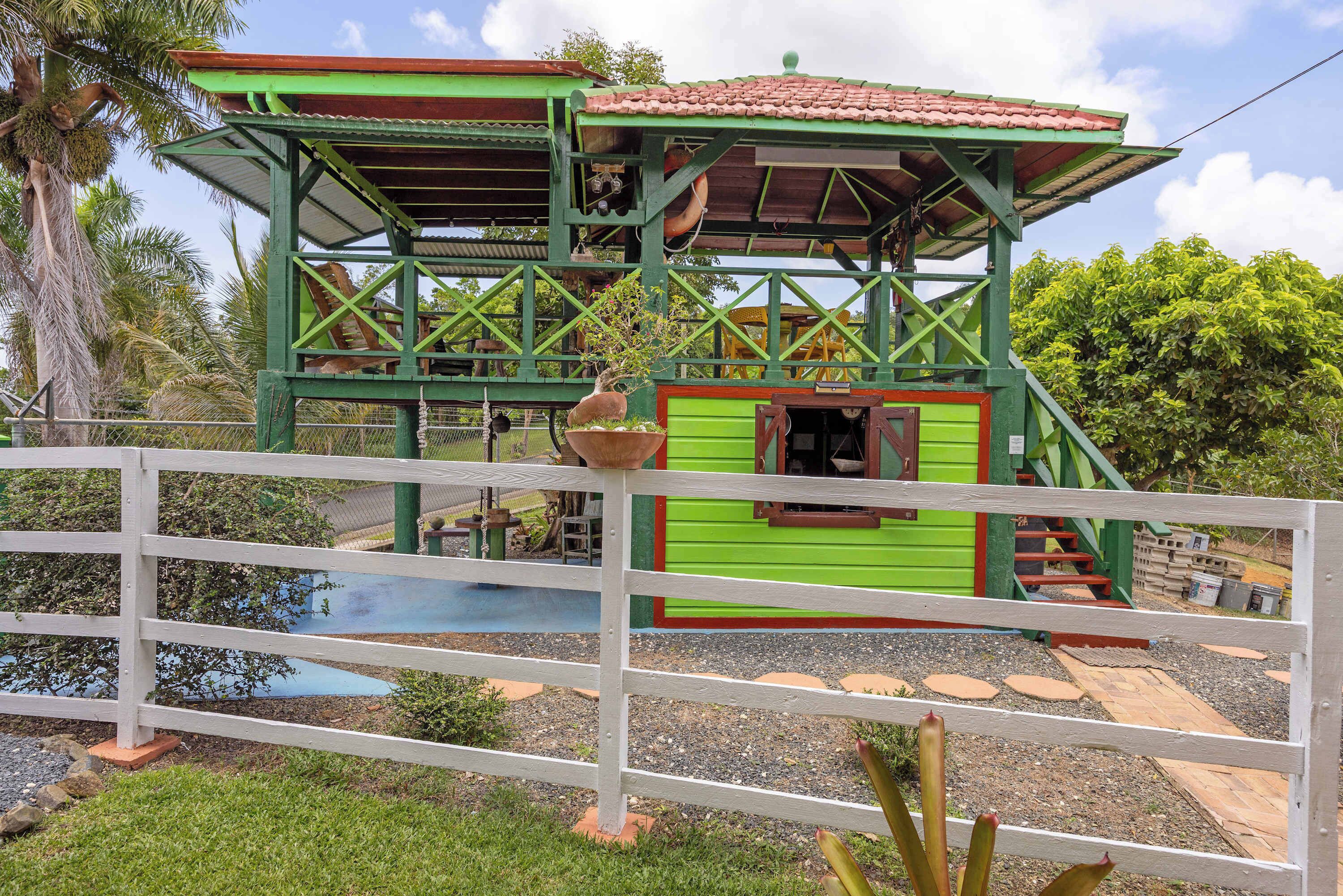 A green and red structure with a roof, a window, and a door.