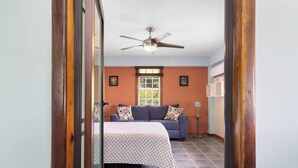 A room with a bed, a ceiling fan, a window, and a sofa. - The Ceiba Villa by Otium (Aguas Claras)