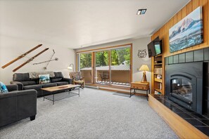A living room with a fireplace, a sofa, a coffee table, and a TV. - Spacious Mountain Retreat with Private Balcony (Keystone)