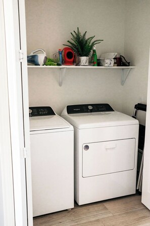 A laundry room with two white front-loading washers and a shelf above containing various items. - Reel It Inn is a 3/2 home in St James City. 3 kayaks,dock space, hottub, 2 bikes (Saint James City)