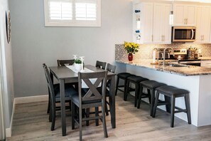 A modern kitchen with white cabinets, a microwave, and a granite countertop. - Reel It Inn is a 3/2 home in St James City. 3 kayaks,dock space, hottub, 2 bikes (Saint James City)