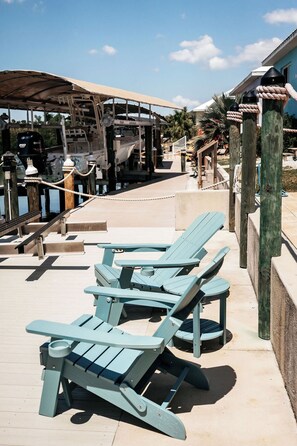 A waterfront deck with lounge chairs and a covered area, likely for relaxation. - Reel It Inn is a 3/2 home in St James City. 3 kayaks,dock space, hottub, 2 bikes (Saint James City)