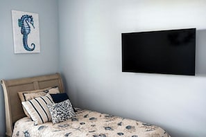 A bedroom with a bed, pillows, a mounted television, and a wall-mounted artwork. - Reel It Inn is a 3/2 home in St James City. 3 kayaks,dock space, hottub, 2 bikes (Saint James City)