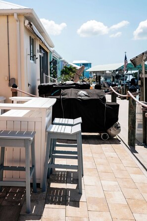 An outdoor patio area with a barbecue grill, a table, and a chair. - Reel It Inn is a 3/2 home in St James City. 3 kayaks,dock space, hottub, 2 bikes (Saint James City)