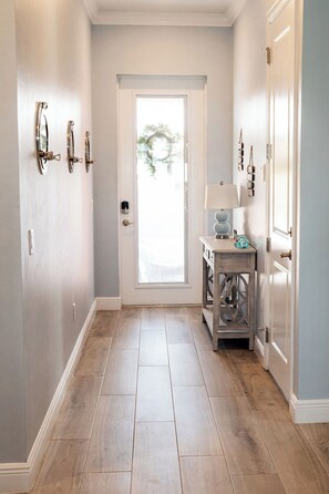 A hallway with a wooden floor, a door at the end, and a small table with a lamp. - Reel It Inn is a 3/2 home in St James City. 3 kayaks,dock space, hottub, 2 bikes (Saint James City)