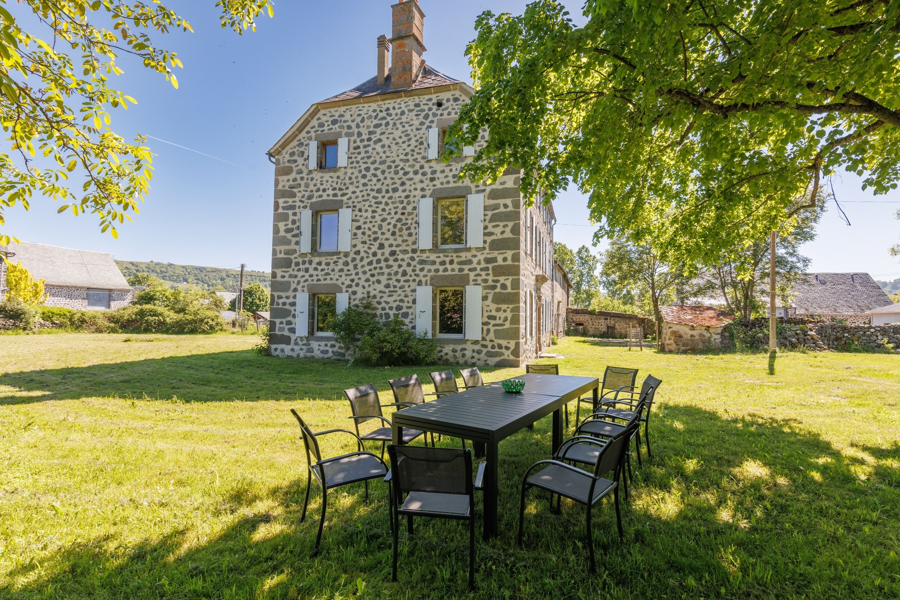 Un bâtiment en pierre avec un espace repas situé à l’avant.