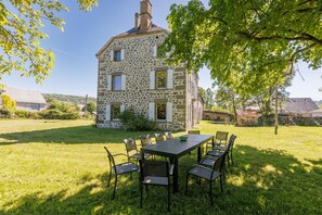 Un bâtiment en pierre avec un espace repas situé à l’avant.