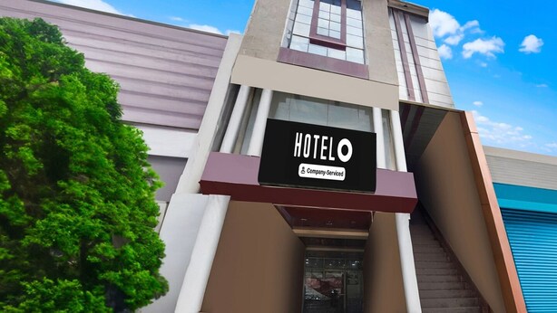Ein Hotelgebäude mit der Aufschrift 'HOTEL O' und 'Company-Serviced'.