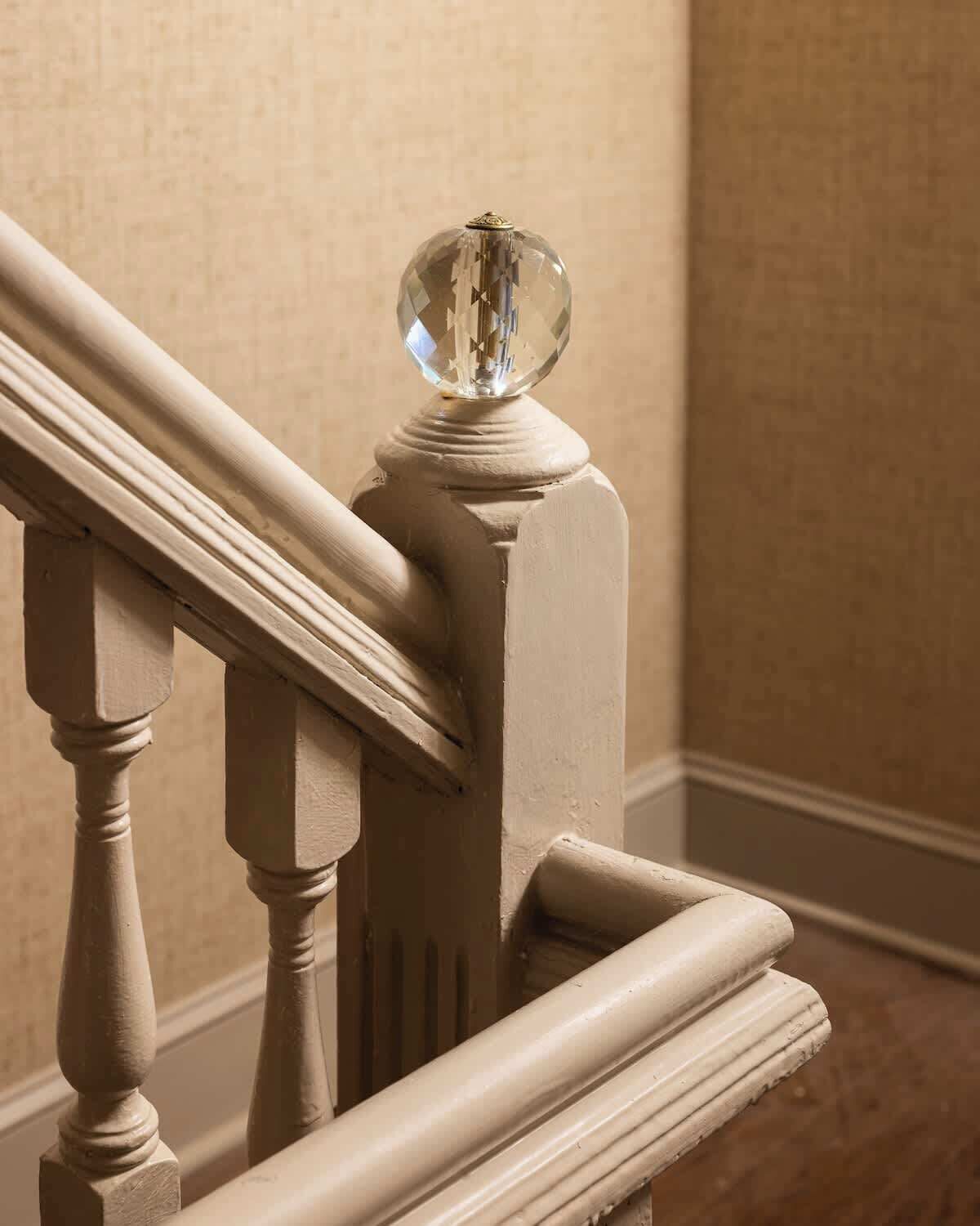 A staircase with a balustrade and a decorative glass sphere at the top.