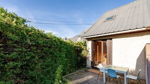 A small house with a paved patio, a table, and two chairs. - Le Pré de l'Arche - À 400 m des télécabines (Oz)