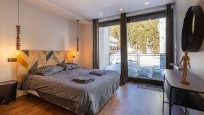 A modern bedroom with a bed, bedside tables, a desk, and a large window with a view. - Le Refuge d'Égat - Avec vue imprenable sur les montagnes (Font-Romeu-Odeillo-Via)