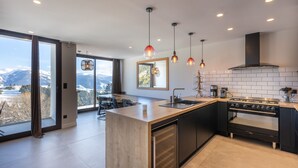 A modern kitchen with a large island, stainless steel appliances, and pendant lighting. - Le Refuge d'Égat - Avec vue imprenable sur les montagnes (Font-Romeu-Odeillo-Via)