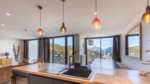 A modern kitchen with a large island, a sink, and pendant lights. - Le Refuge d'Égat - Avec vue imprenable sur les montagnes (Font-Romeu-Odeillo-Via)