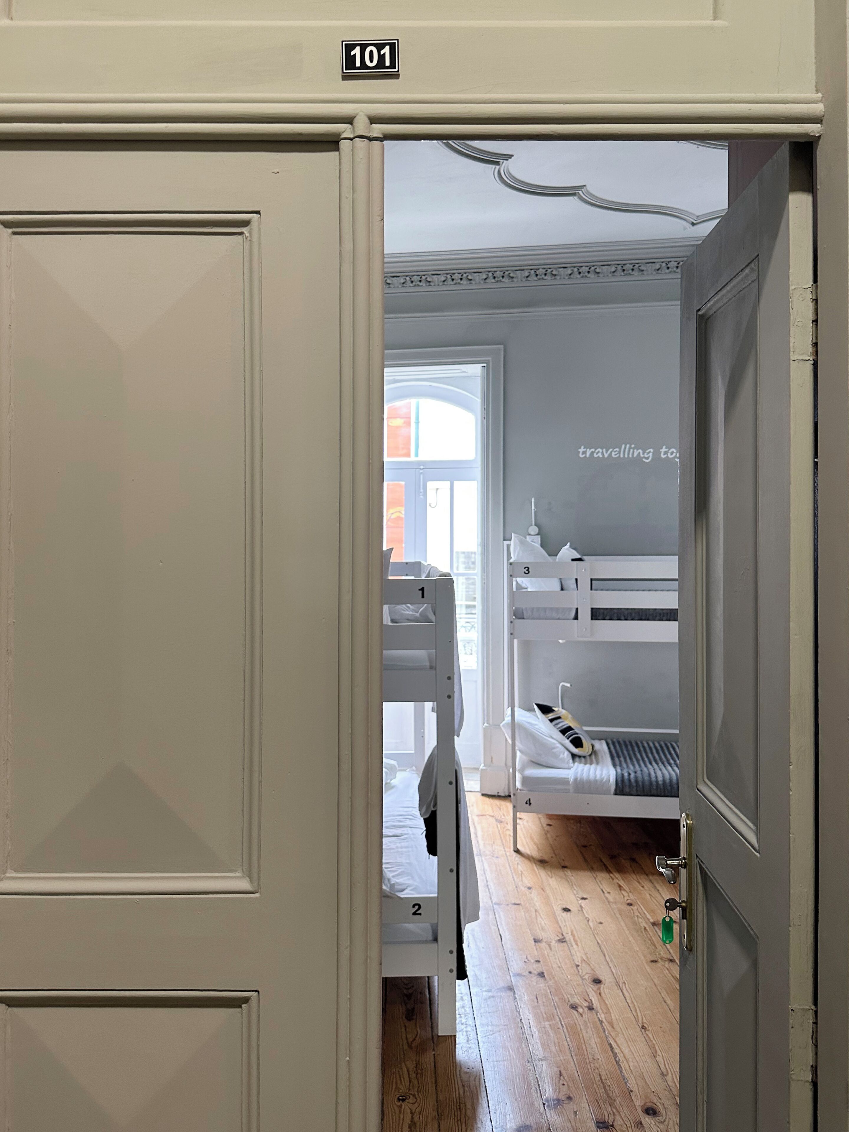 Una habitación con literas, una puerta con el número 101 y vistas al exterior.