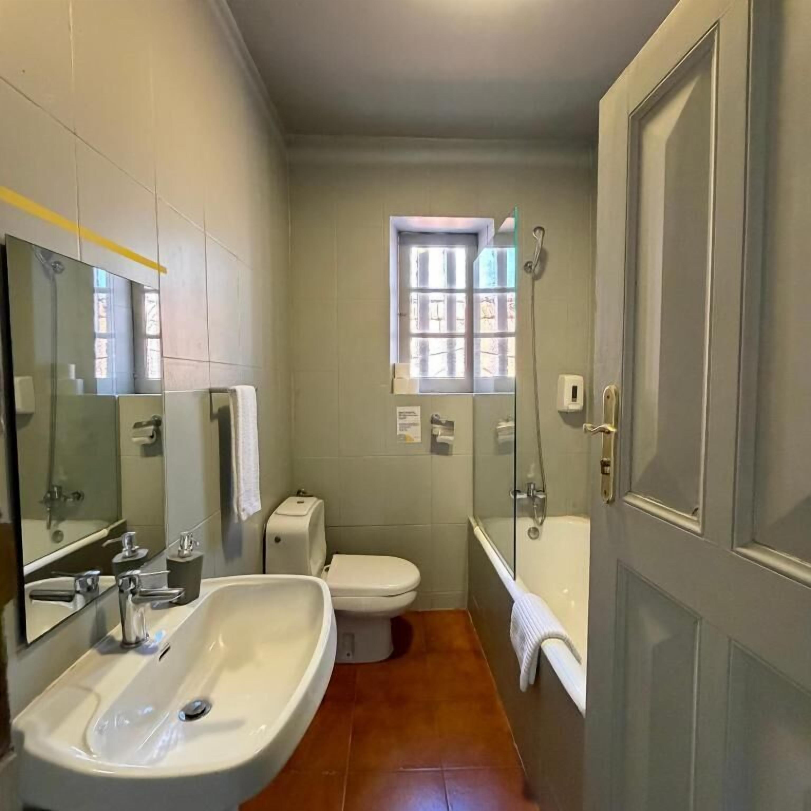 A bathroom with a sink, toilet, and bathtub.