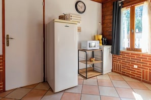 Eine kompakte Küche mit Kühlschrank, Mikrowelle und einer kleinen Schrankwand.