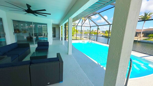 A covered outdoor area with a pool, seating, and a view of a body of water. - Relaxing House with Gulf Access & Heated Pool (Cape Coral)