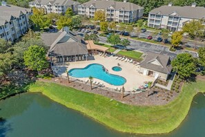 A residential area with a swimming pool, a small pond, and apartment buildings. - 1610 Crow Creek Drive (Calabash)