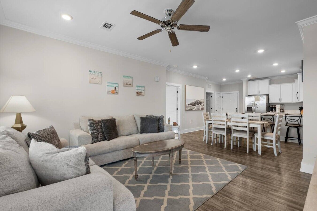 Un salon avec un canapé, une table basse et un ventilateur de plafond.