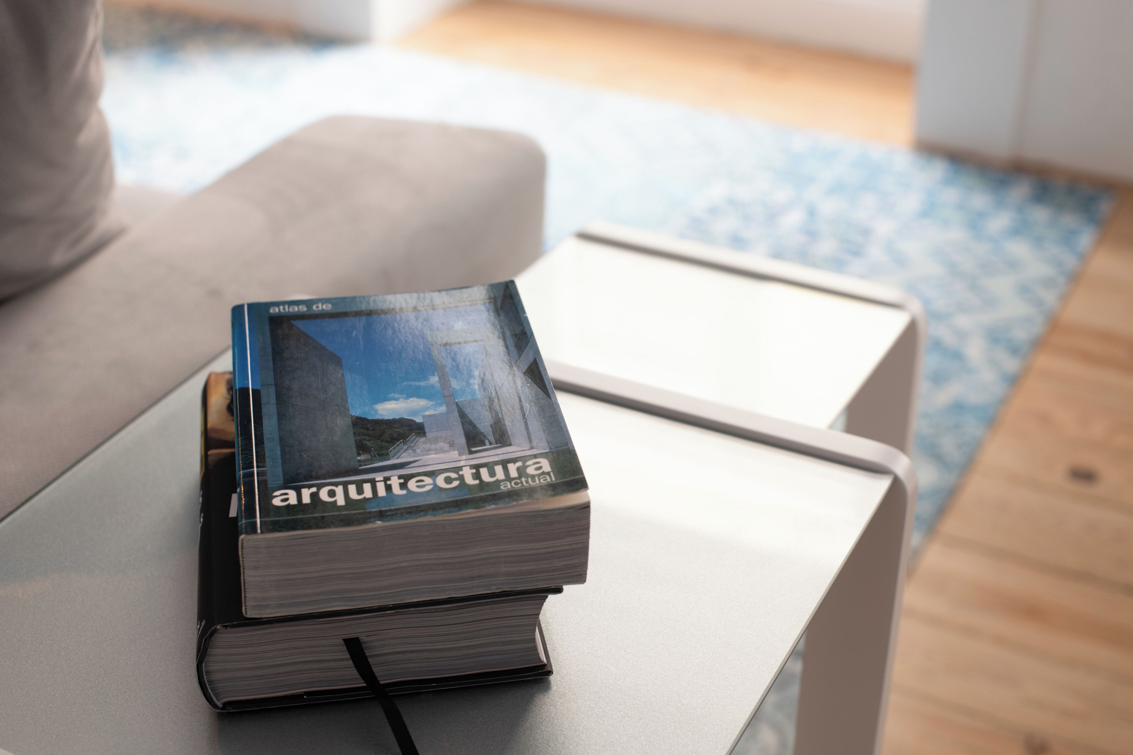 A book titled 'arquitectura actual' on a white table.