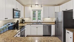 A kitchen with white cabinets, a stainless steel refrigerator, a dishwasher, a microwave, and granite countertops. - Private Coastal 2 BD Residence in Ocean Park ME (Old Orchard Beach)