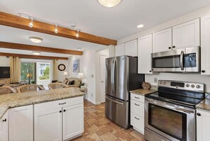 A modern kitchen with white cabinetry, stainless steel appliances, and a granite countertop. - Private Coastal 3 BD Residence in Ocean Park (Old Orchard Beach)