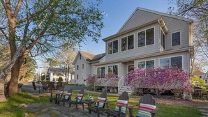 A two-story house with a stone pathway leading to outdoor seating. - Private Coastal 3 BD Residence in Ocean Park (Old Orchard Beach)