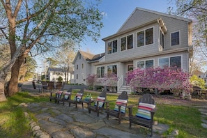 A two-story house with a stone pathway leading to outdoor seating. - Private Coastal 3 BD Residence in Ocean Park (Old Orchard Beach)