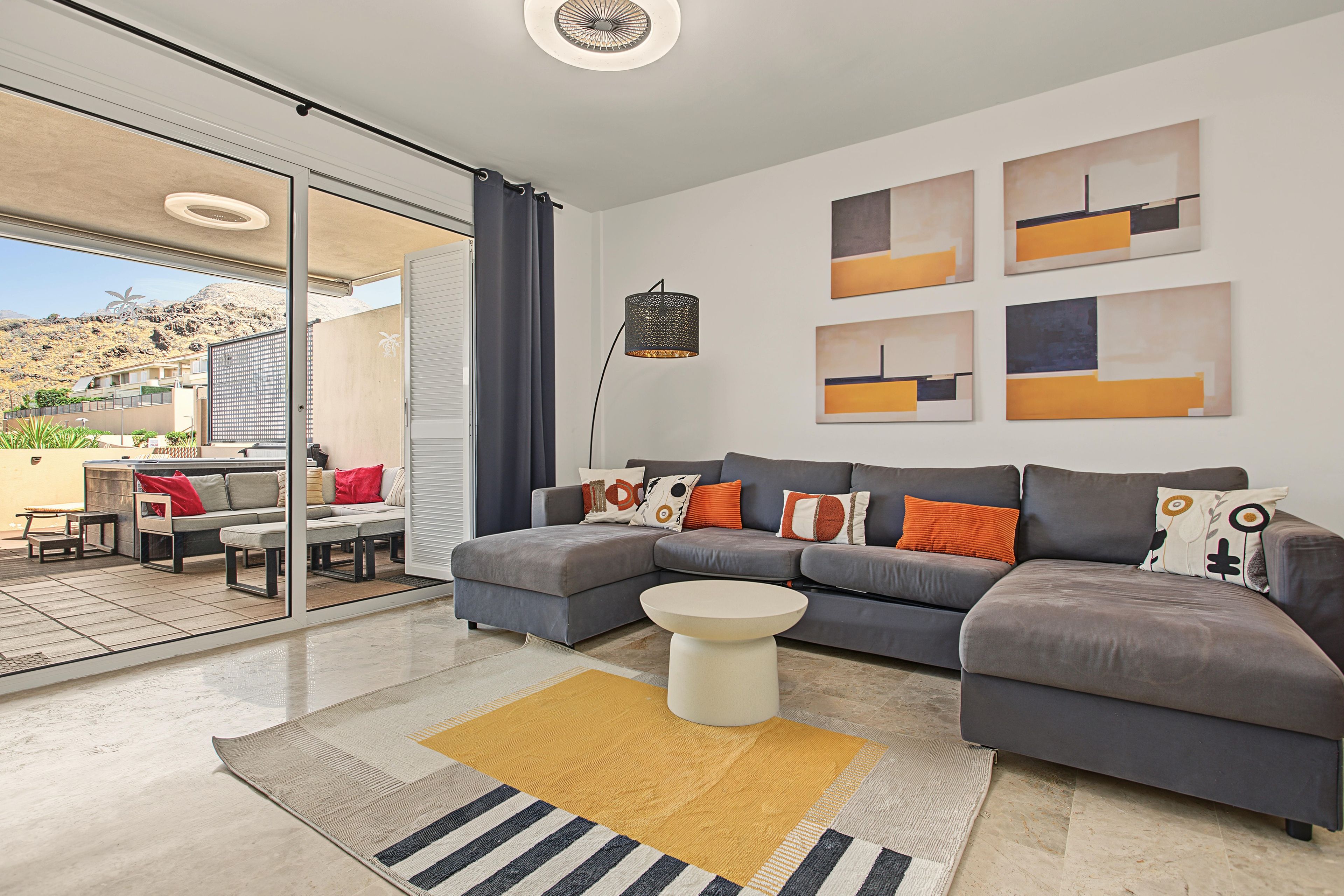 A modern living room with a sectional sofa, a coffee table, and abstract wall art.
