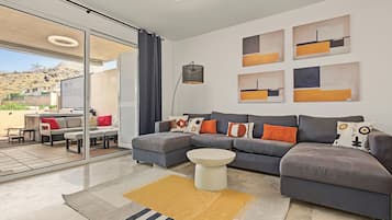 A modern living room with a sectional sofa, a coffee table, and abstract wall art.