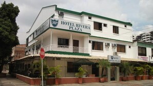 Un edificio de dos plantas con un letrero que dice 'Hotel Rivera Plaza'.