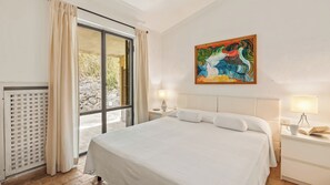 A hotel room with a large bed, two bedside tables with lamps, a window with curtains, and a painting on the wall. - Villa Althaea 6, Emma Villas (Orbetello)