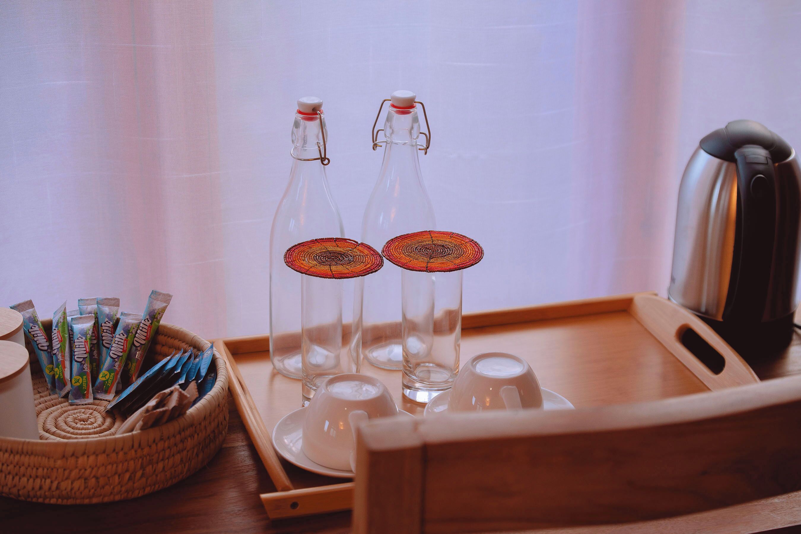 A tray with two glass bottles and a basket of snack packets.