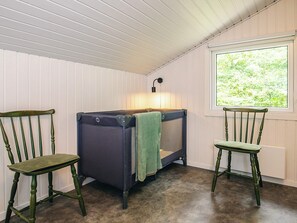 A room with a bed, a lamp, and two chairs.