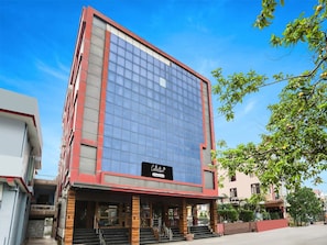 A modern building with a glass facade, a sign reading 'Collection,' and a staircase leading to the entrance. - Suite Collection O Tikonia (Haldwani)