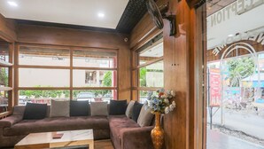 Een modern interieur met een bank, een houten salontafel en een decoratieve vaas.