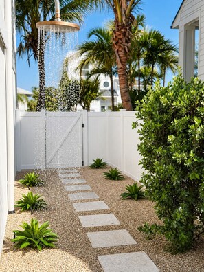 A garden with a water feature, stepping stones, and various plants. - Heart of Pine Ave | 6 En-Suites | Heated Pool (Anna Maria)