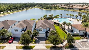 A residential area with houses, a swimming pool, and a lake. - Upstay Lake View Villa with Hot Tub, Pool & Resort (Kissimmee)