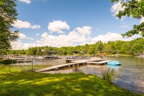 Un quai au bord du lac, avec des bateaux, une zone abritée et une végétation luxuriante.