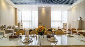 Ein Hotelrestaurant mit mehreren Tischen, Stühlen und einer zentralen Blumenkomposition.